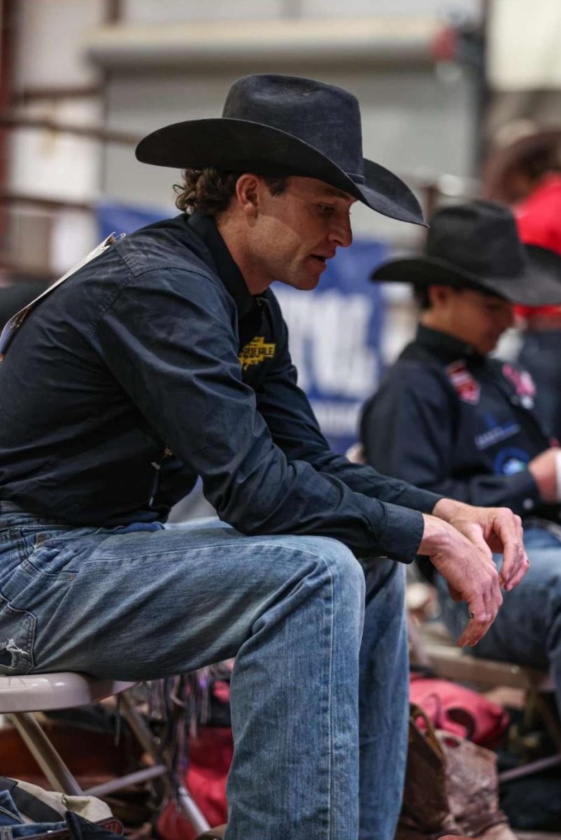 Powell High School graduate and bronc rider Brody Wells watches others compete.