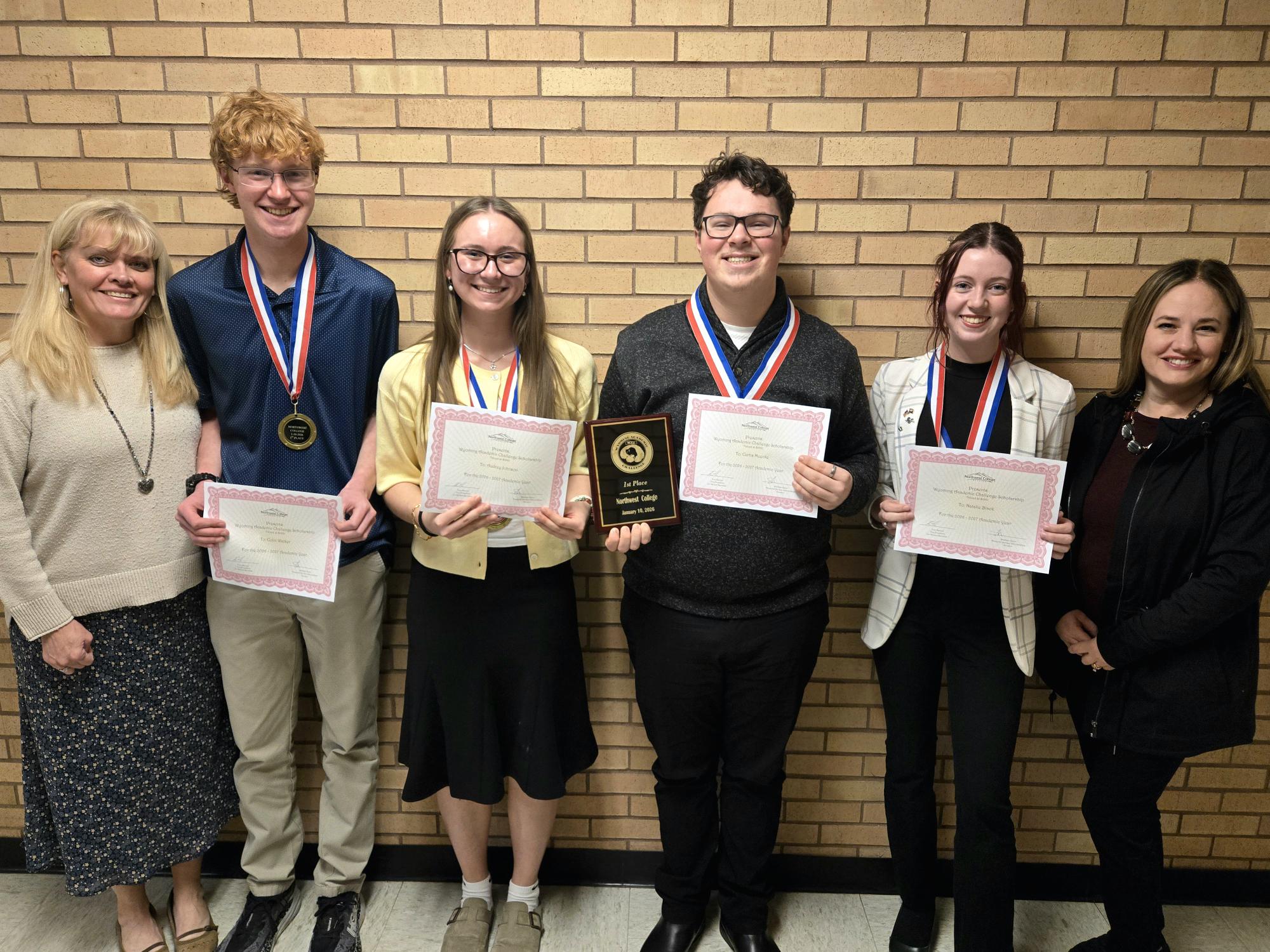 Wyoming Academic Challenge participants, Coach Tracy McArthur, Colin Walker, Audrey Johnson, Curtis Muecke, Natalie Black, and Coach Amy Moore celebrate their 1st place trophy and $1,000 scholarships.