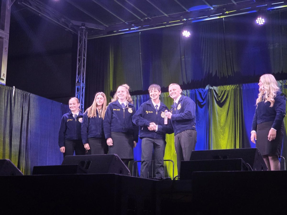 Left to Right: junior Tanis Ginest, freshman Brooklyn Kyniston, freshman Autumn Allred, freshman Blake Bessler, and 25-26 state parliamentary handing ribbons to the wool judging team
(Courtesy Photo)