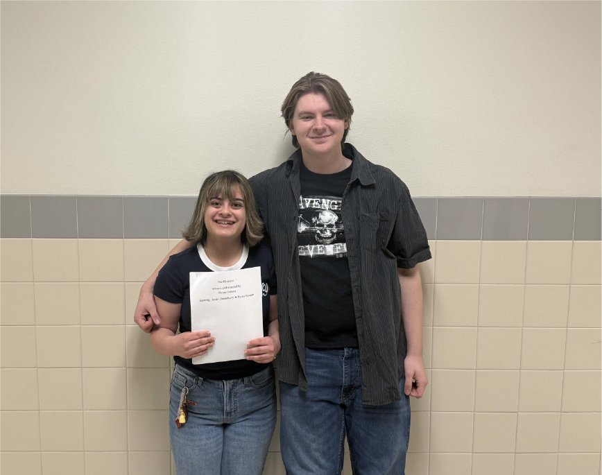 Reina Hansen and Justin Dusenberry display a copy of their film script.
